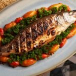 Deliciously grilled fish served with tomatoes and parsley on an elegant platter.