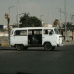 Old minibus on a sunlit street in Cairo, showcasing local urban transport.